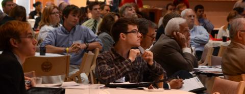 A crowd gathered in the Chestnut Room listens to a speaker.
