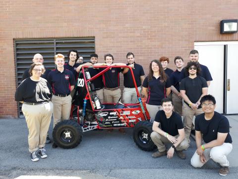 Members of the 2022 SAE Baja team pose with this year's vehicle